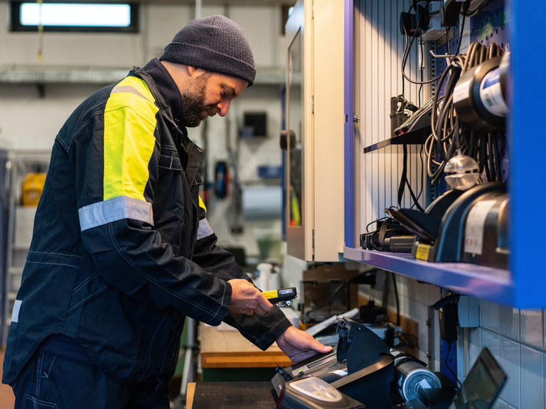 Werkstattarbeit mit Sicherheitstechnik Person bedient ein Dräger Sicherheitsgerät in der Werkstatt.