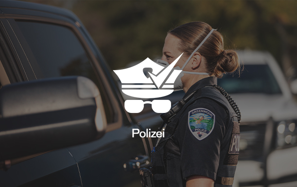 Polizistin mit Maske guckt in Autofenster
