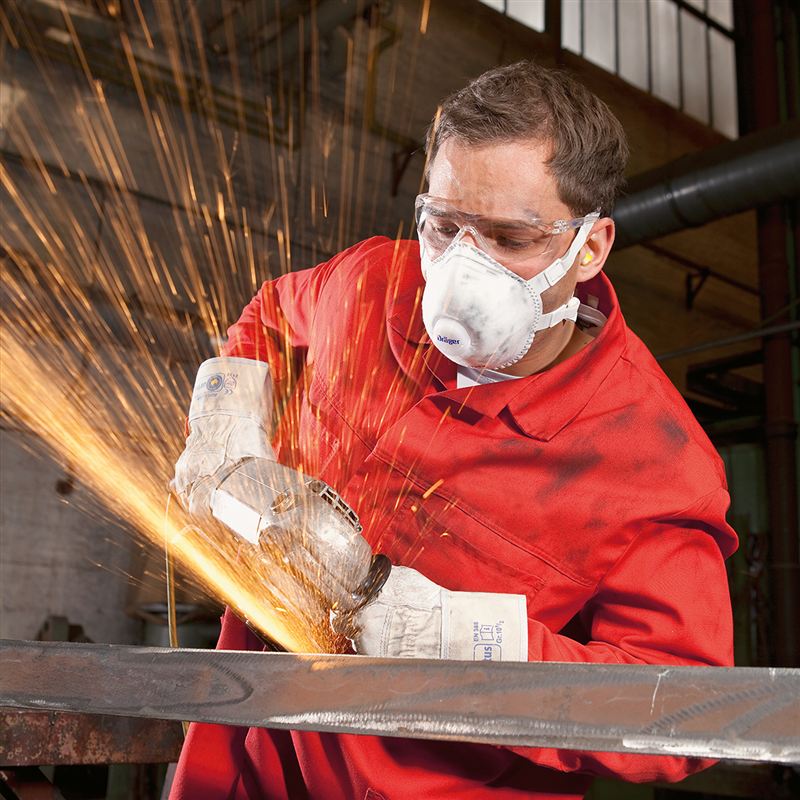 Staubmaske für Industrielle Metallbearbeitung Person bearbeitet Metall mit Winkelschleifer in Werkstatt.