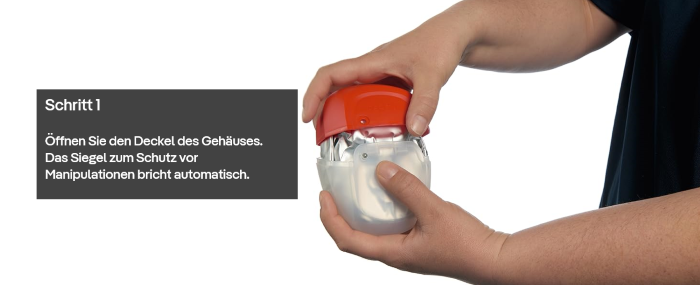 Hände öffnen das Gehäuse eines Sicherheitsfluchtgeräts.