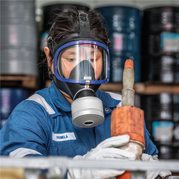 Schutzmaske mit K2 Filter in Anwendung Person trägt Atemmaske mit Rd40 K2 Filter, blaues Arbeitsoutfit.