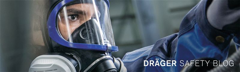 Dräger Schutzmaske in Aktion Mann mit Dräger Vollmaske, fokussiert auf Sicherheit.