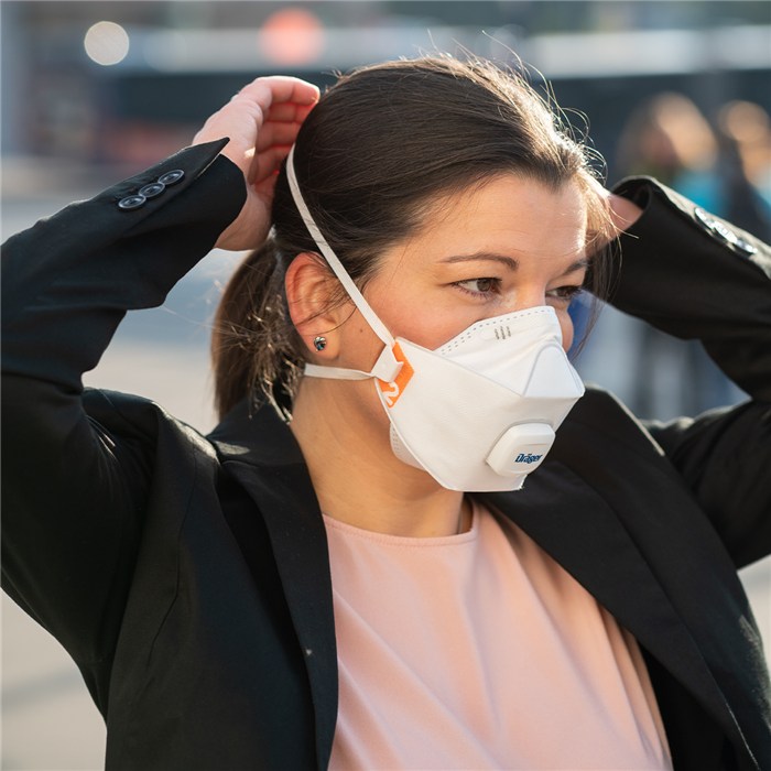 Atemschutzmaske X-plore 1920 V in Anwendung Person zieht eine Atemschutzmaske über den Kopf.