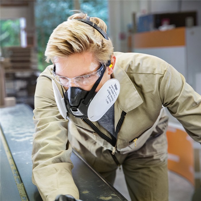 Dräger X-plore 3500 Atemschutzmaske Person trägt Dräger X-plore 3500 Atemschutzmaske in einer Werkstatt.