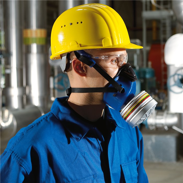 X-plore 4740 TPE Halbmaske im Einsatz Person trägt X-plore 4740 TPE Halbmaske vor Industrieanlage.