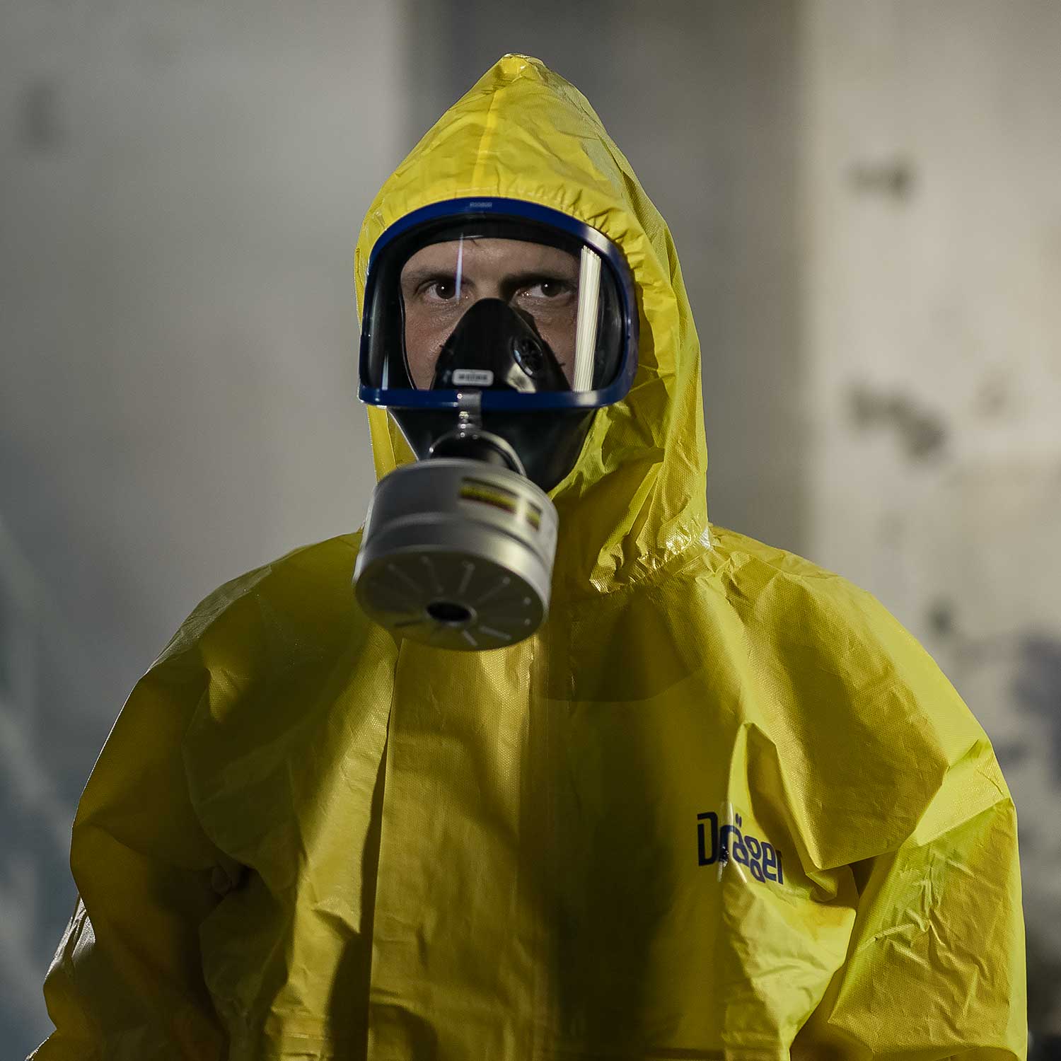Person in Schutzanzug mit Dräger Atemschutzmaske und Filter.