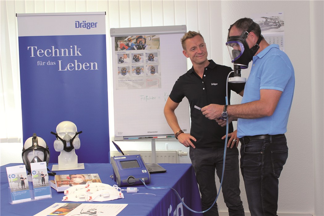 Atemschutzgerätetest bei Dräger Zwei Personen testen ein Atemschutzgerät am Dräger Stand.