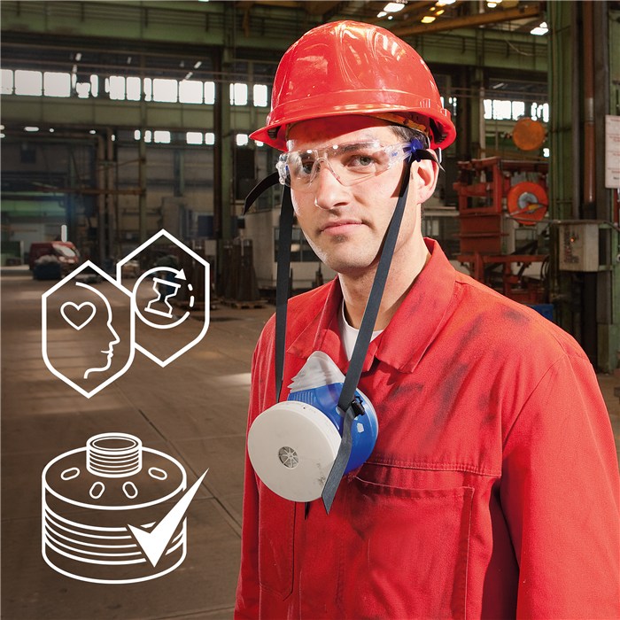 Person in roter Arbeitskleidung trägt die X-plore 4740 Silikon-Halbmaske im industriellen Umfeld.