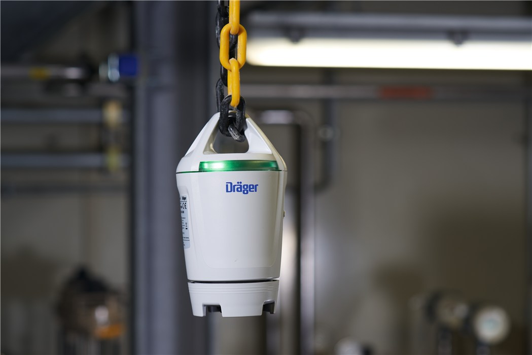 Weißer Dräger Gasdetektor hängt an gelber Kette.