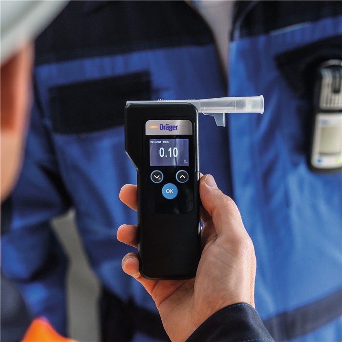 Draeger Alcotest 6000 im Einsatz Person hält ein Draeger Alcotest 6000 vor einem Sicherheitsbeamten.