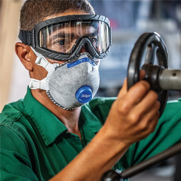 Atemschutzmaske X-plore 1330V Odour Person trägt Schutzmaske und arbeitet an einer Maschine.