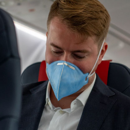 Mann mit FFP3 Maske im Flugzeug