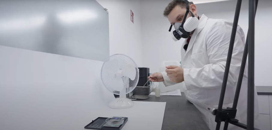Halbmaske für Chemiesicherheit bei Dräger Person mit Halbmaske in Schutzanzug im Laborumfeld