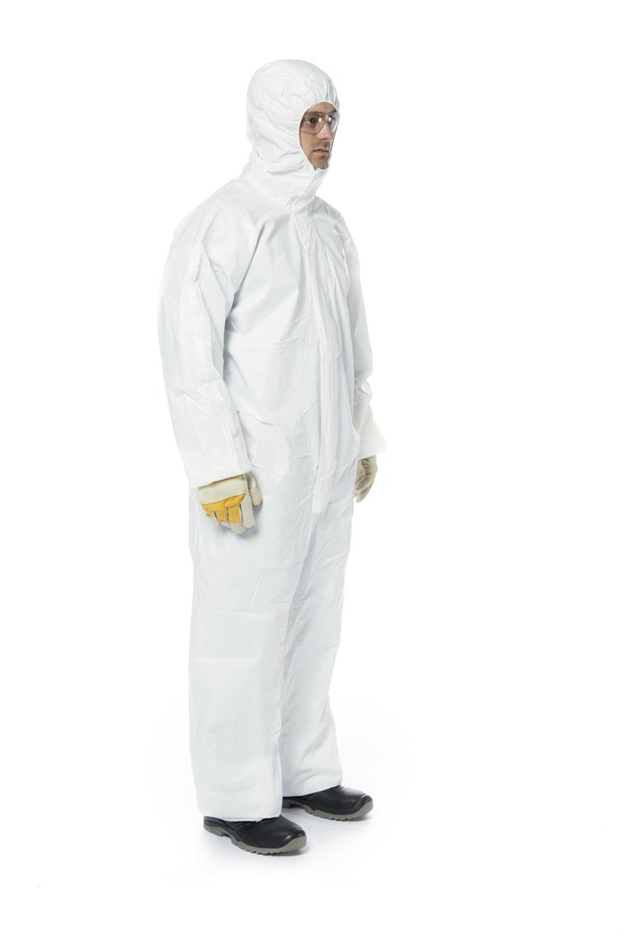 Mann in weißem Schutzanzug, mit Handschuhen und Schutzbrille.