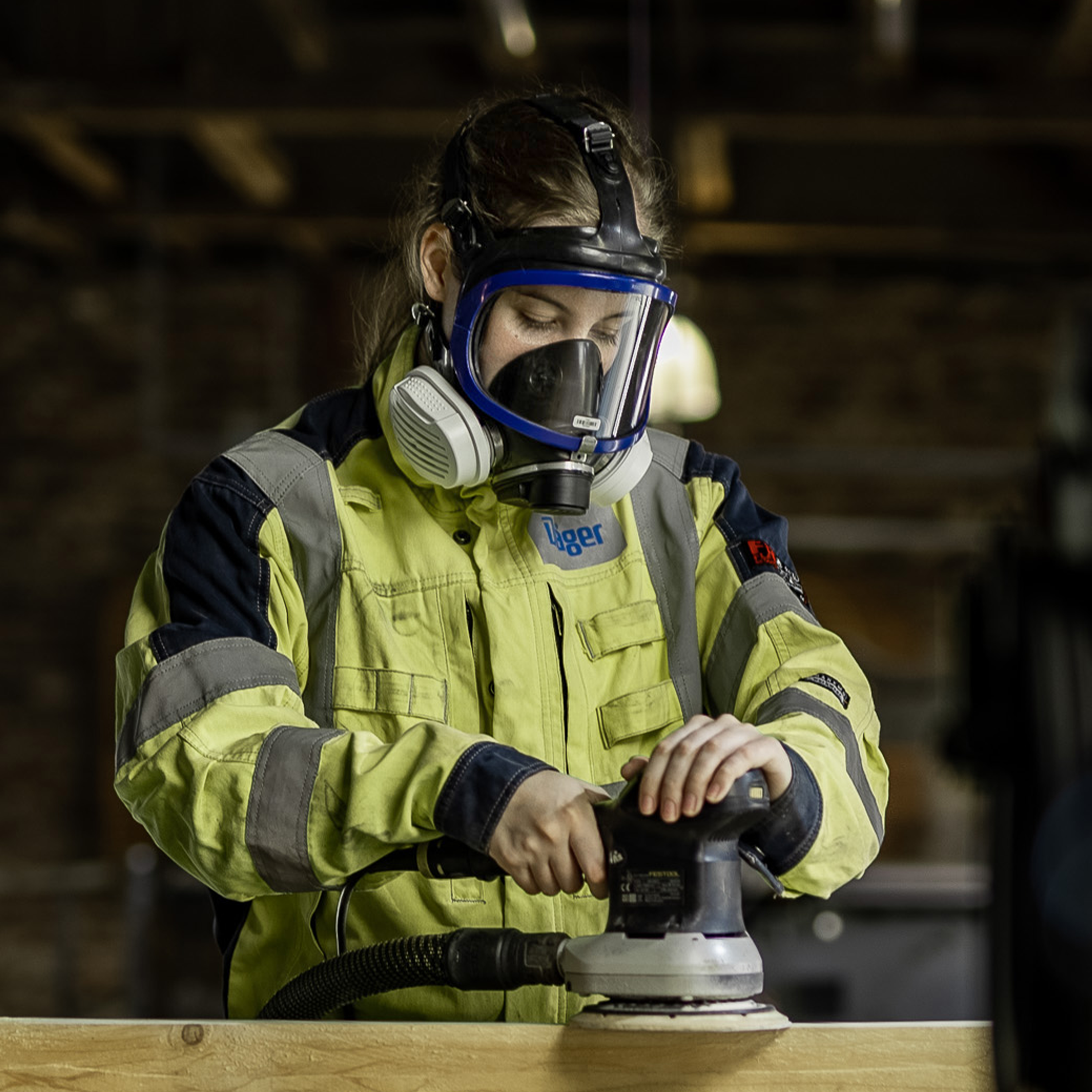 Sicherheitstechnikausrüstung beim Schleifen Person beim Schleifen mit Dräger Schutzmaske und Schleifgerät.