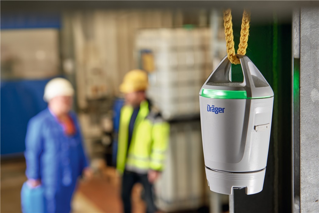 Dräger X-node Sicherheitstechnik Zwei Arbeiter in Schutzkleidung, hinten unscharf, Fokus auf Dräger Gerät.