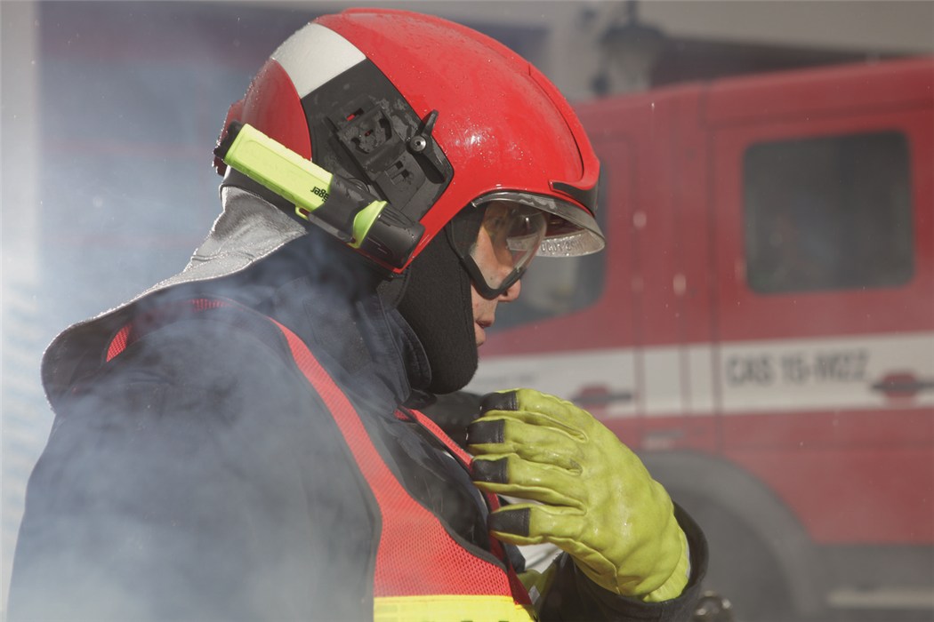 Feuerwehrmann mit Atemschutzgerät Feuerwehrmann in Schutzkleidung vor Einsatzfahrzeug.