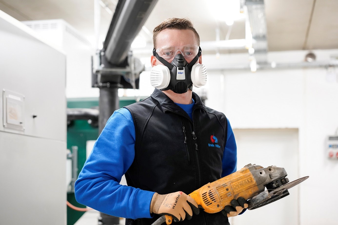 Sicherheitstechniker bei der Arbeit Person hält eine Motorsäge in einer Werkstatt.