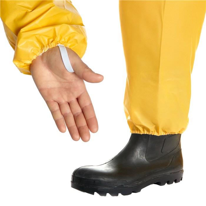 Schutzanzug SPC 4400 und Stiefel Gelber Schutzanzug mit Gummistiefel, Hand zeigt auf Details.