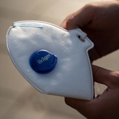 FFP-Maske mit Ventil von Dräger Nahaufnahme einer weißen FFP-Maske mit blauem Ventil.