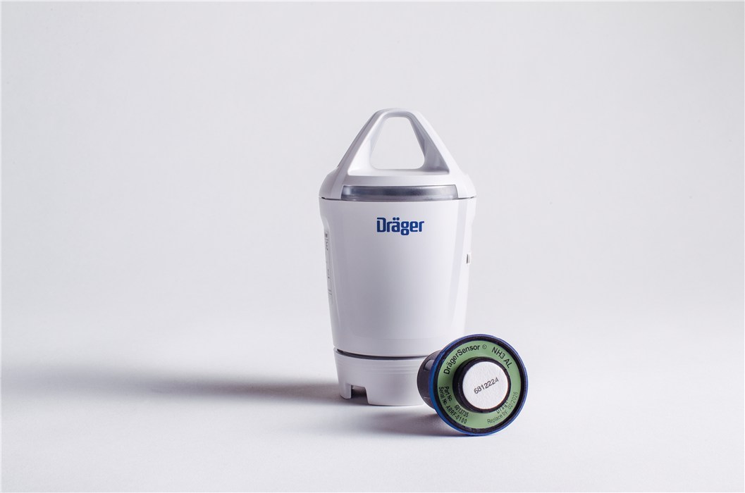 Weißer Dräger Gassensor und grünes Modul auf weißem Hintergrund.