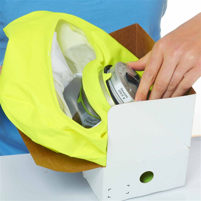 Dräger PARAT 5510 – Atemschutzgerät Person entnimmt ein gelbes Atemschutzgerät aus einer Verpackung.