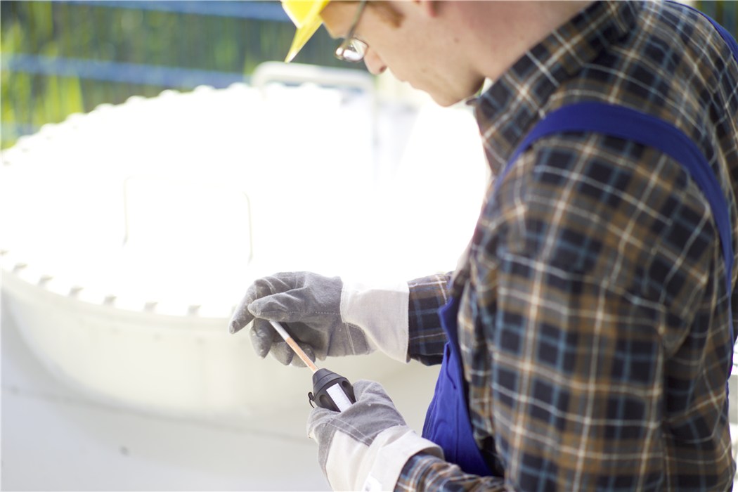 Gasmessgerät in Aktion Person mit Schutzkleidung hält ein Gasmessgerät.