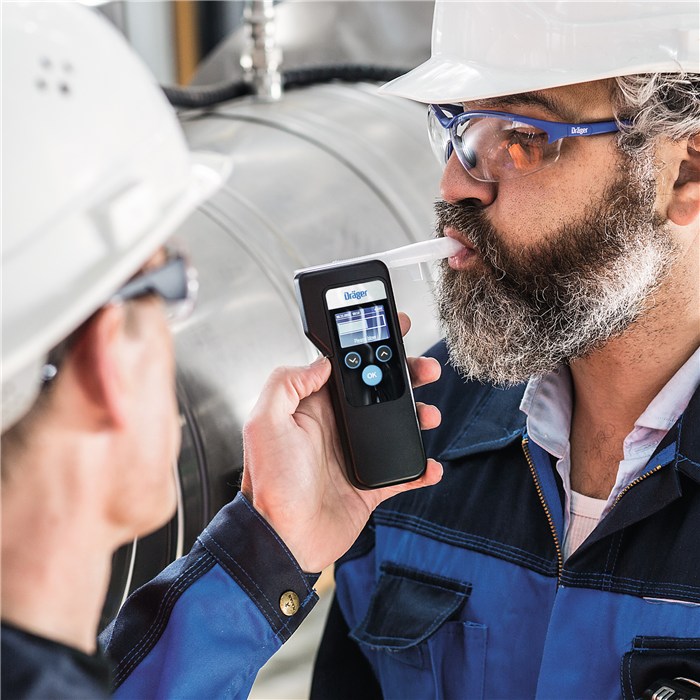 Dräger Alcotest 6000 im Einsatz Zwei Personen benutzen einen Dräger Alcotest 6000 Alkoholtester im industriellen Umfeld.