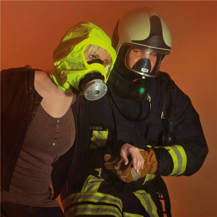 Rettung mit PARAT 5510 Atemschutzmaske Person mit gelber PARAT 5510 Atemschutzmaske neben Feuerwehrmann.
