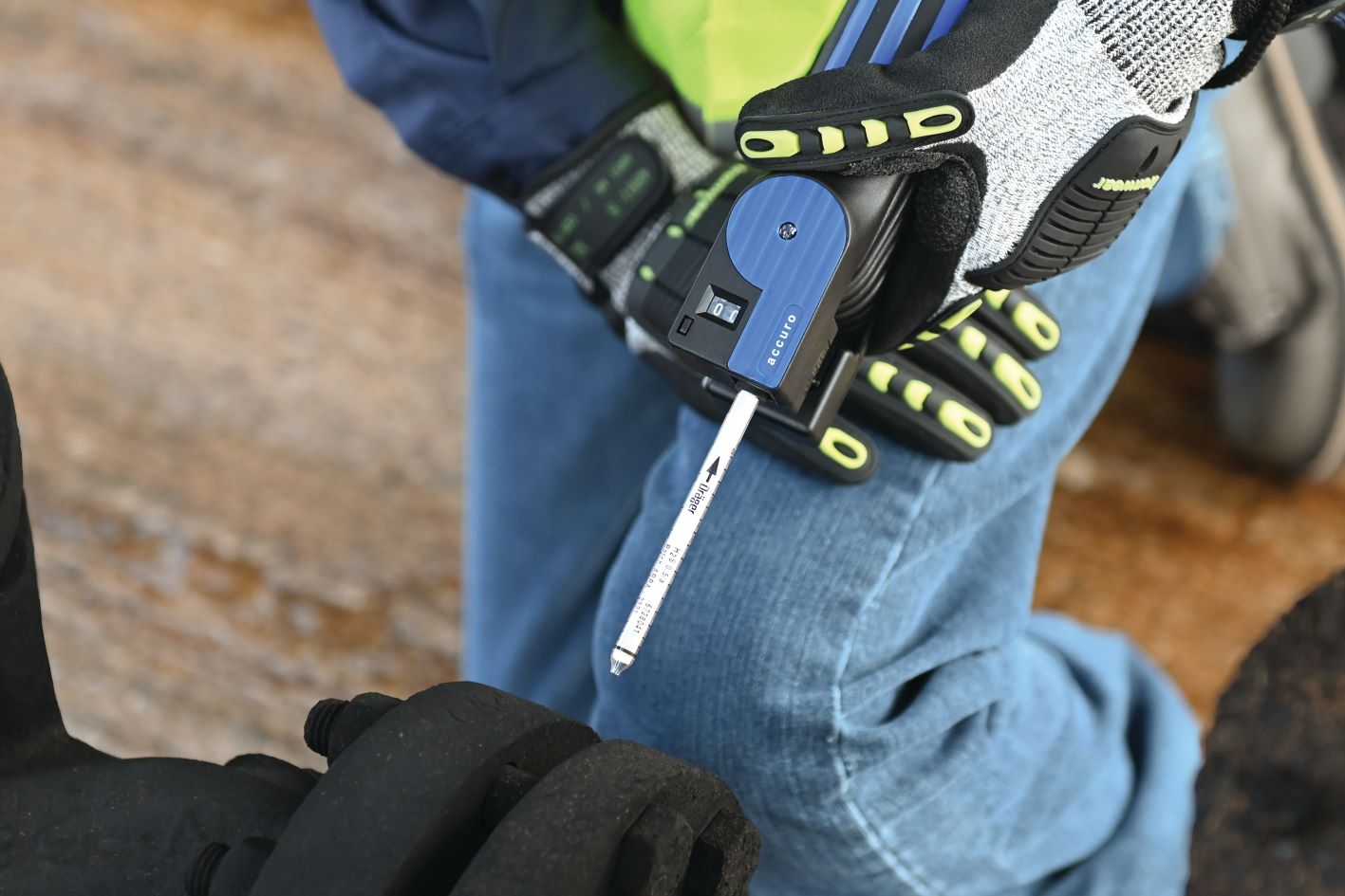 Person hält eine Dräger Accuro Pumpe, umgeben von Sicherheitshandschuhen und Schutzkleidung.