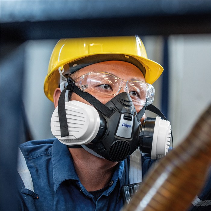Schutzbrille Dräger X-pect 2400 Person mit gelbem Schutzhelm und Atemschutzmaske.