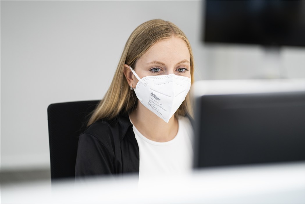 Arbeitsplatz bei Dräger Sicherheitstechnik Person im Büro sitzend am Computer-Arbeitsplatz.