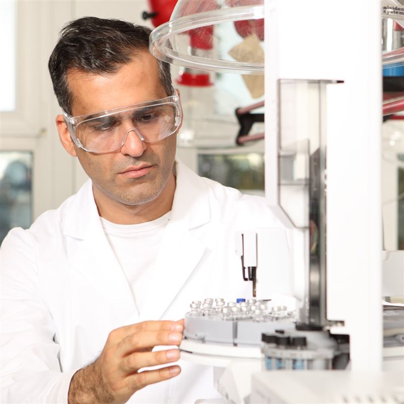 Schutzbrille X-pect 8110 in Laborumgebung Wissenschaftler im Labor mit automatischem Analysegerät.