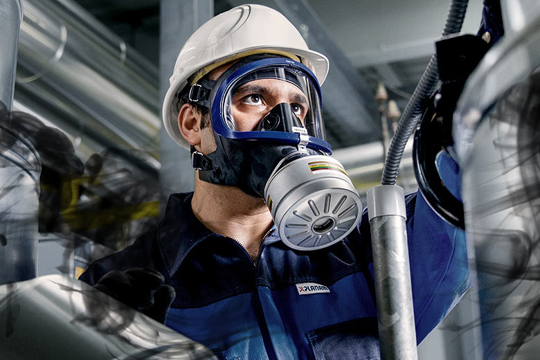 Dräger RD40 Kombinationsfilter in Aktion Person trägt Schutzmaske und Filter in industrieller Umgebung.