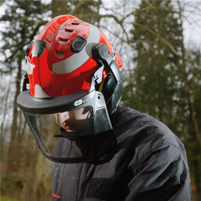 Draeger HPS 3500 Schutzhelm Person mit rotem Schutzhelm und Gesichtsschutz im Wald.