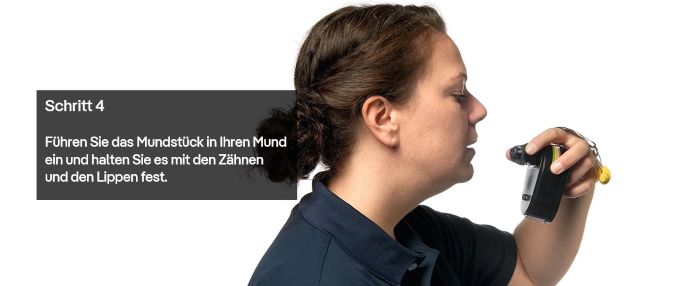 Person legt Mundstück des Fluchtgeräts an.