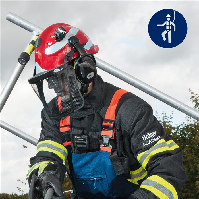 Schutzhelm Draeger HPS 3500 in Aktion Feuerwehrmann mit rotem Draeger-Schutzhelm und Gesichtsschutz bei Übung im Freien.