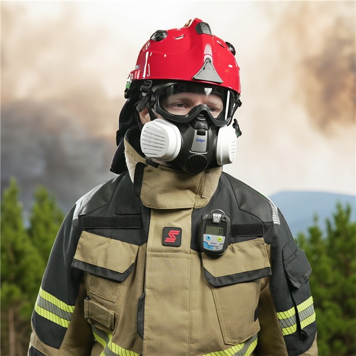 Schutzbrille X-pect 4200 im Einsatz Feuerwehrmann trägt Schutzbrille und Helm vor Rauchkulisse. Kleidung mit Reflektorstreifen und Funkgerät.