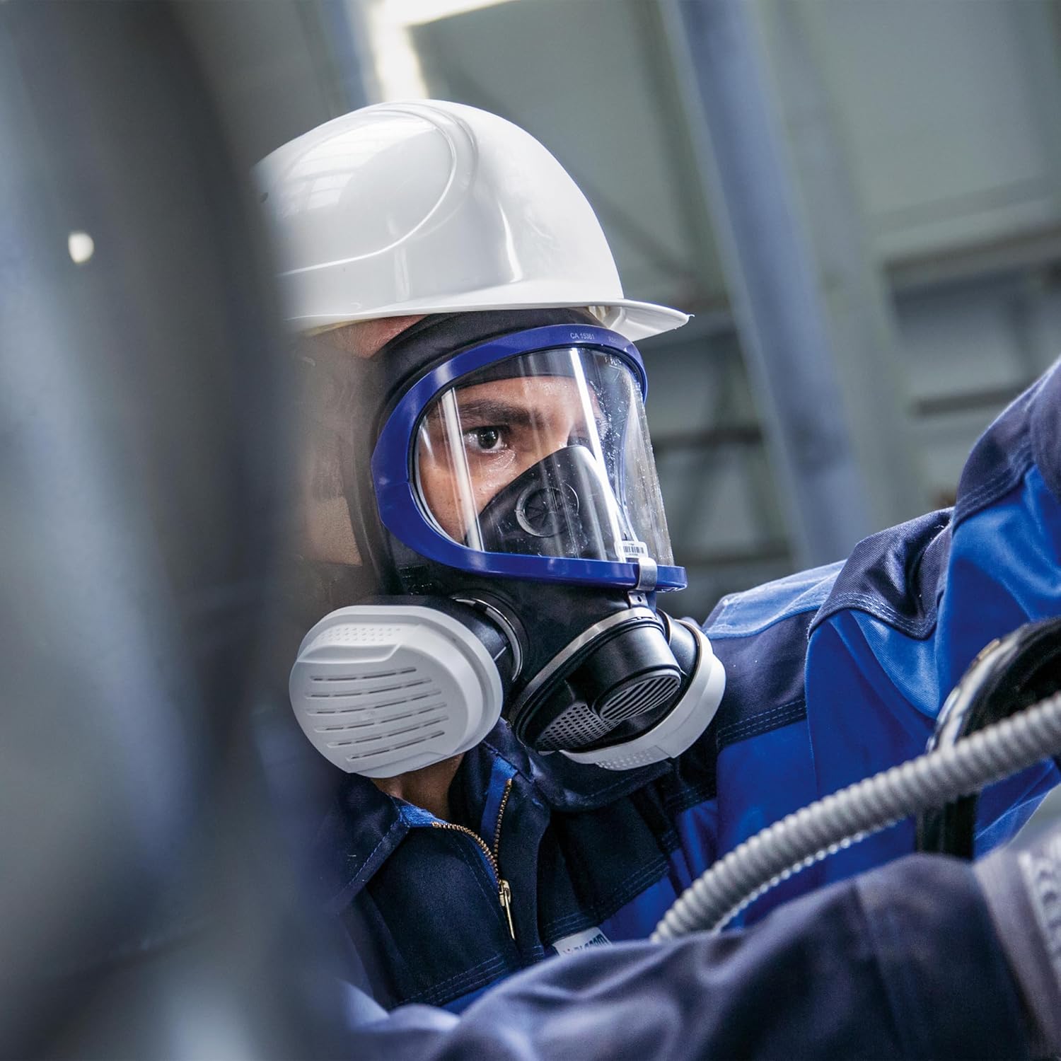 Vollmaske Draeger X-plore 5500 im Einsatz Person trägt Draeger X-plore 5500 Vollmaske mit Filtersystem bei der Arbeit in einer industriellen Umgebung.